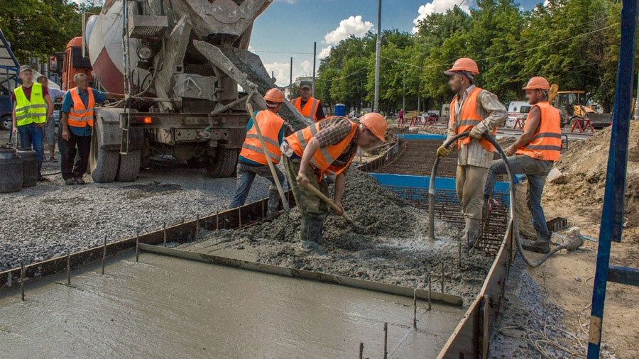 Concrete works for road construction with many workers and mixer timelapse