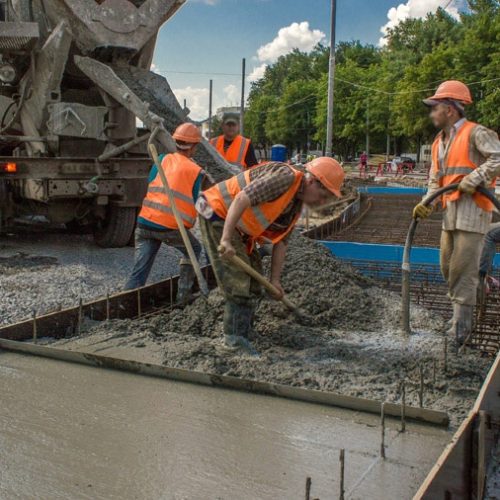Concrete works for road construction with many workers and mixer timelapse